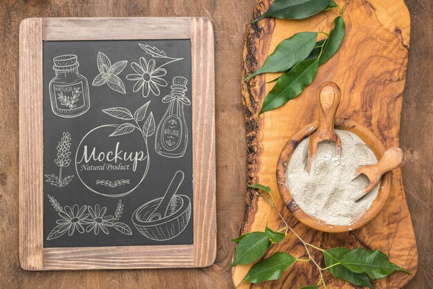 PSD top view of natural powder in bowl with leaves and blackboard