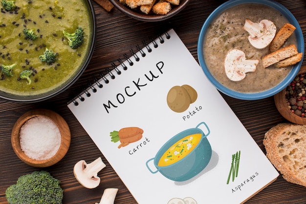 Top view of notebook with bowls of soup