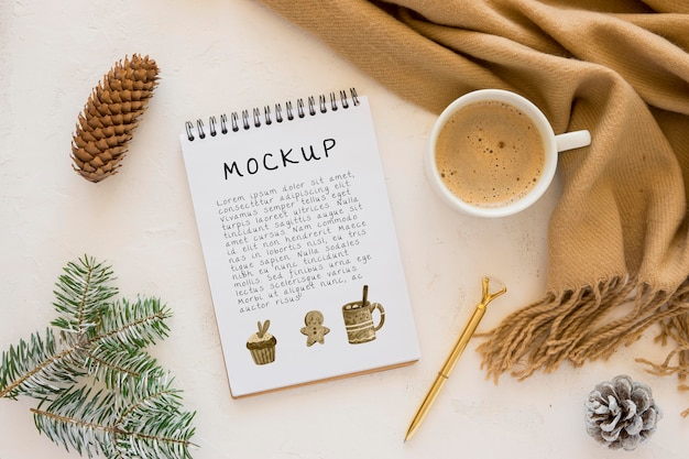 Top view of notebook with coffee and pine cones