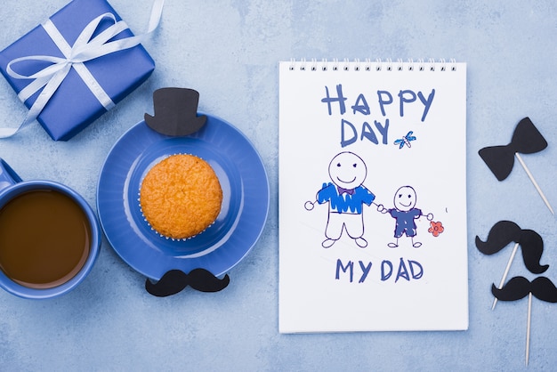 PSD top view of notepad with gift and cupcake for fathers day