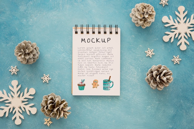 top view of notepad with pine cones and snowflakes