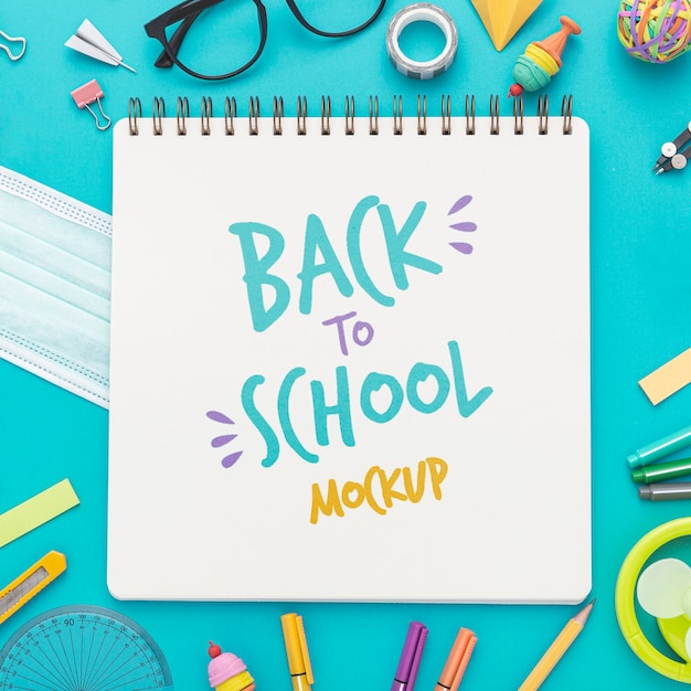 top view of back to school notebook with glasses and pencils