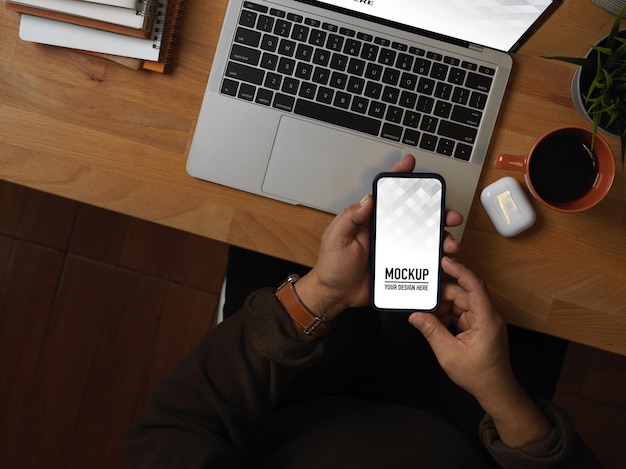 PSD スマートフォンのモックアップを使用して男性の手の上面図