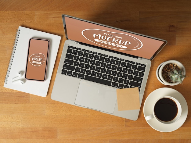Вид сверху макета цифровых устройств с ноутбуком, смартфоном, кофейной чашкой, канцелярскими принадлежностями и аксессуарами