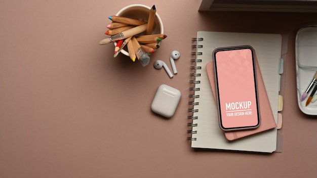 Top view of workspace with smartphone mockup and accessories