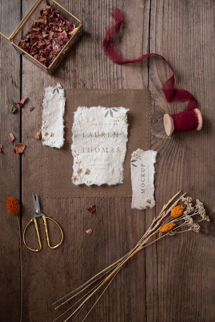 Top view of paper mock-up rustic wedding invitation with leaves and flowers