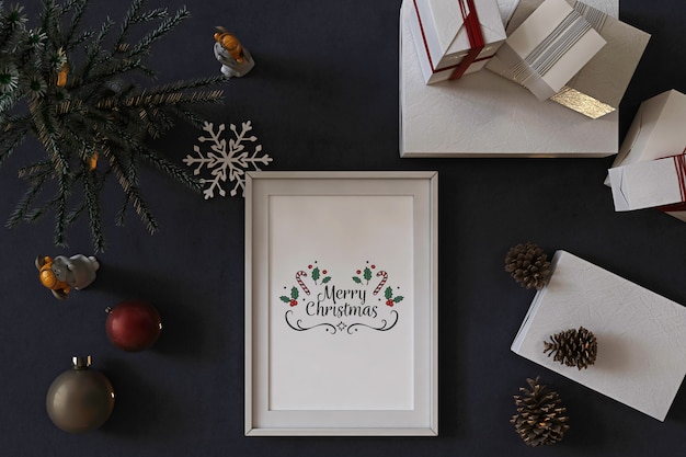 Vista dall'alto del mockup di cornice per poster con albero di natale, decorazioni e regali