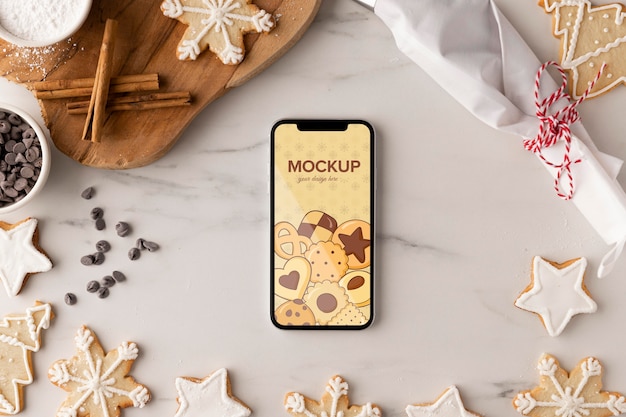 Top view of smartphone mock-up with snowflake cookies and cinnamon