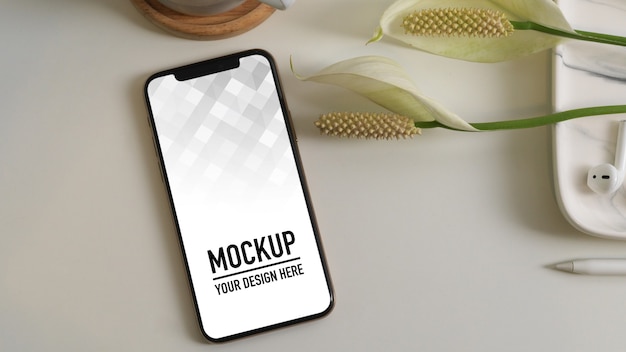 Vista dall'alto del mockup di smartphone con accessorio e fiore