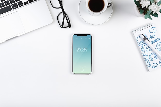 PSD top view smartphone mockup on workspace