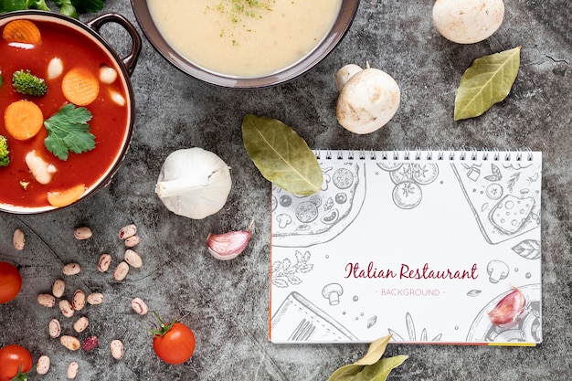 PSD top view soup with assortment of ingredients and notepad mock-up