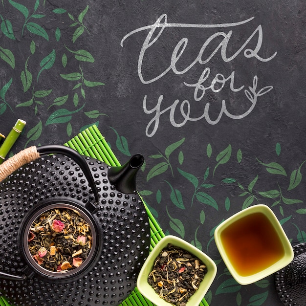 Top view tea pot with tasty herbs concept