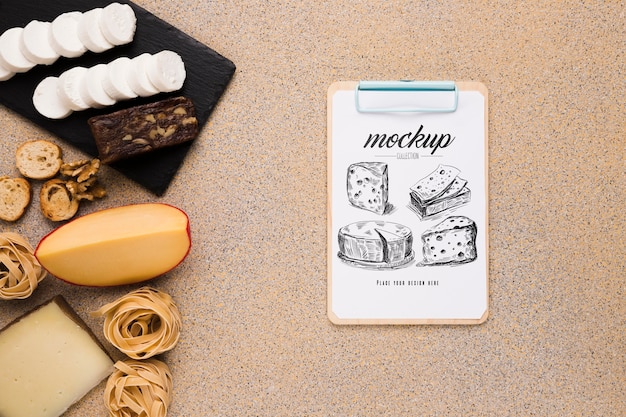 top view of variety of cheese with notepad