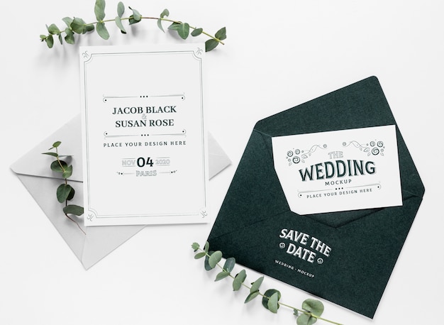 Top view of wedding cards with envelope and plants