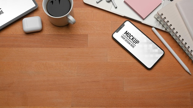 Top view of wooden table with smartphone mockup