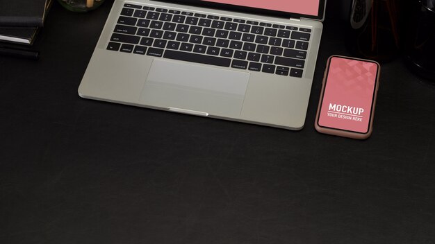 Top view of workspace with laptop and phone mockup