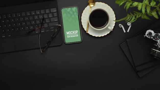 Top view of workspace with smartphone, keyboard, camera, coffee cup and supplies mockup