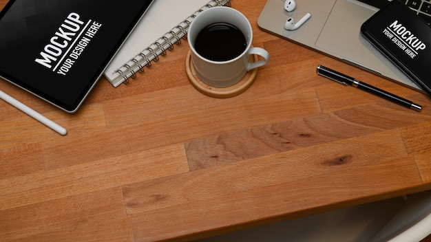 Top view of workspace with smartphone and tablet mockup and office supplies