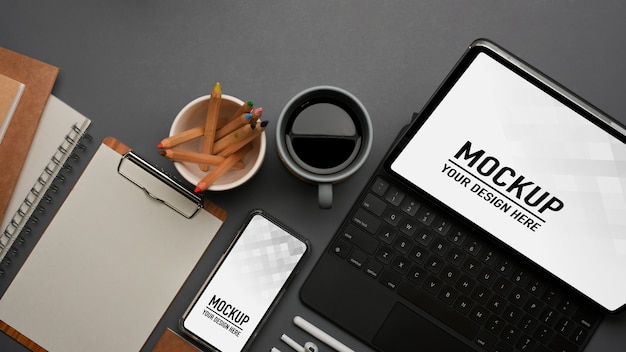 PSD top view of workspace with tablet keyboard and smartphone mockup