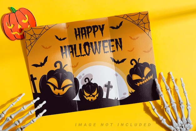 trifold mock-up paper brochure in a skeleton's hands.
