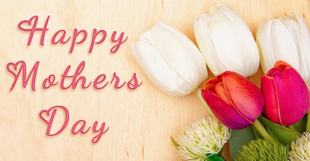 Tulip flowers on wooden background with inscription Happy Mother's Day