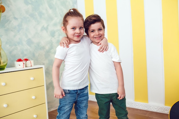 Twee schattige kinderen die elkaar knuffelen en glimlachen.