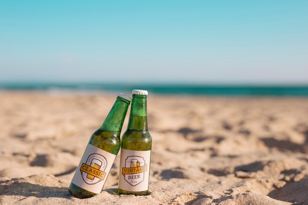 Mockup di due bottiglie di birra in spiaggia