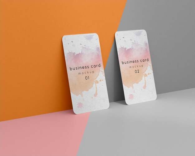 Two business card cards are on a grey and pink background