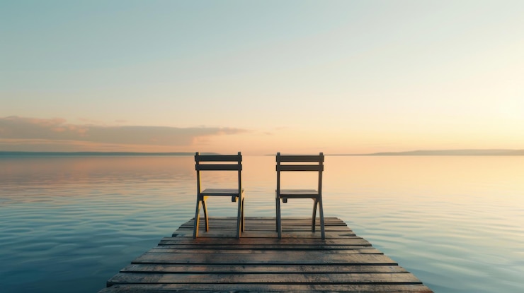 PSD two chairs on a peaceful lake dock at sunset