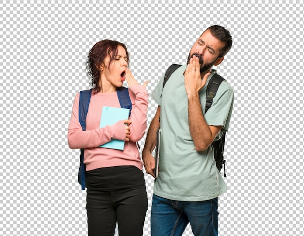 PSD two students with backpacks and books yawning and covering mouth with hand