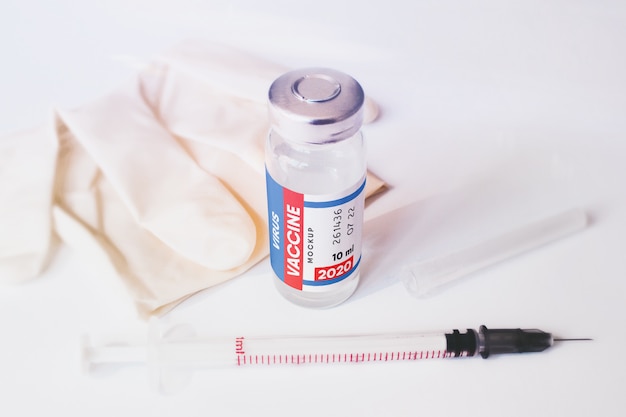 PSD vaccine bottle with syringe and medical gloves scene mockup