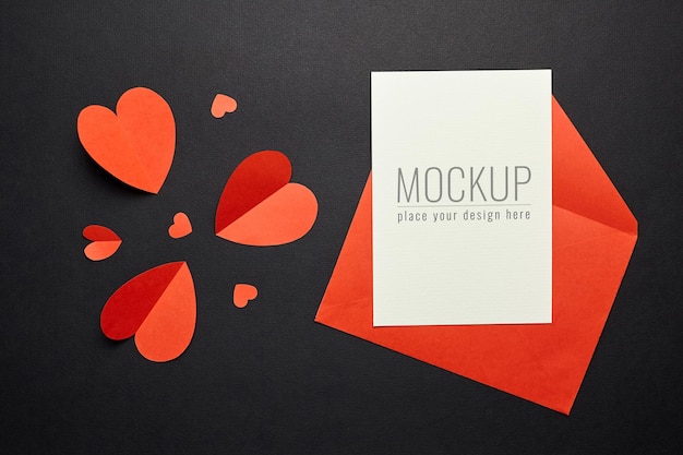 PSD valentines day card mockup with red envelope and hearts on black paper surface