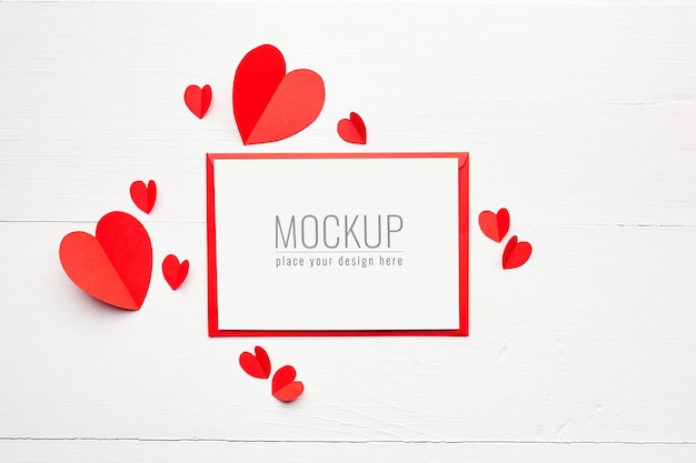 Mockup di carta di san valentino con cuori di carta rossa su bianco