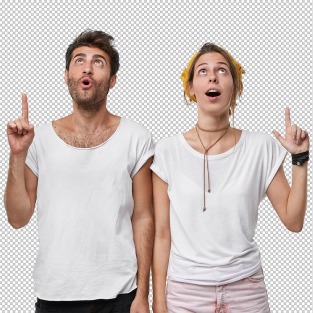 vertical shot of stupefied female and male point both index fingers up indicate something shocking drop jaw concentrated on ceiling