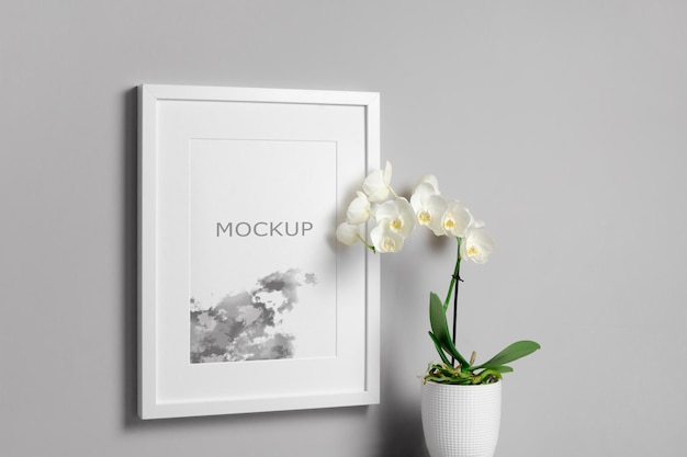 Verticale posterframe mockup met witte orchideebloemen