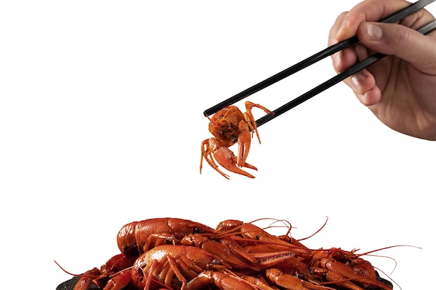 PSD view of cooked crawfish held by hand with chopsticks