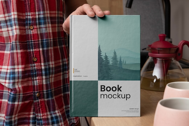 View of hand holding book mock-up