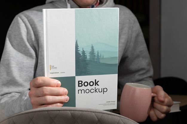 View of hand holding book mock-up