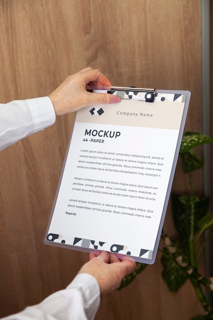 PSD view of human hands holding paper document mock-up