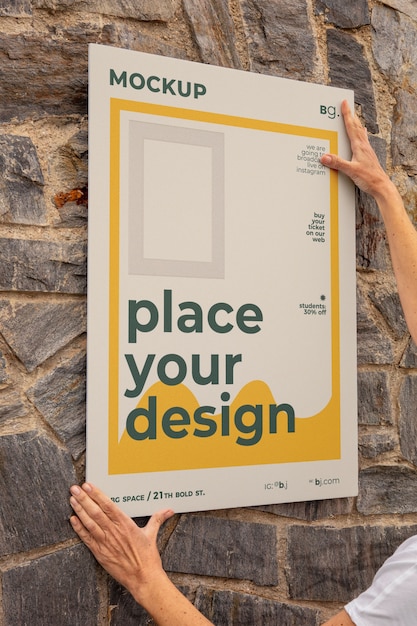 View of person sticking exterior poster mock-up on wall