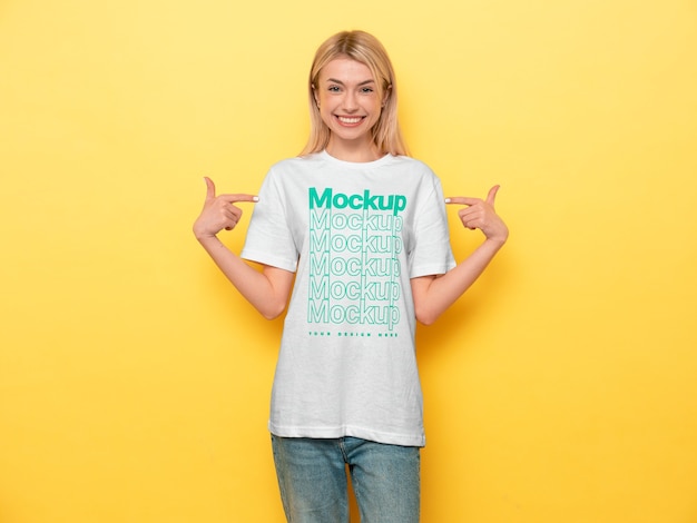 PSD vista della donna che indossa il design del mock-up della t-shirt e che lo indica