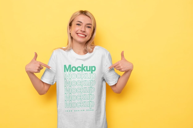 PSD view of woman wearing t-shirt mock-up design and pointing at it