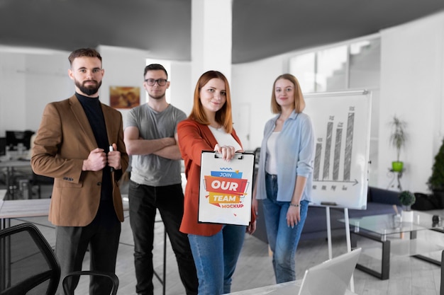 View of work colleagues holding mock-up clipboard