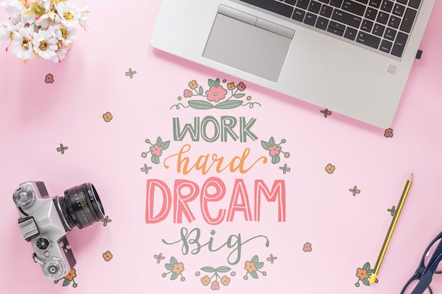 PSD vintage camera laptop and motivational message on desk