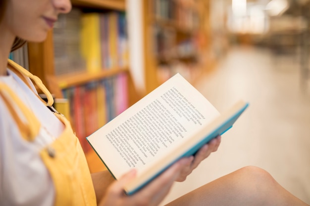 Vooraanzicht van meisjeslezing in de bibliotheek