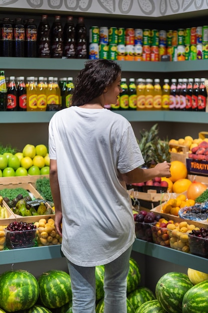 Vrouw bekijkt vers fruit in een supermarkt