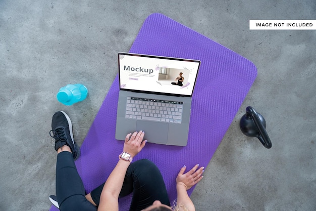 Vrouw beoefenen van sportschool op yogamat met laptop mockup