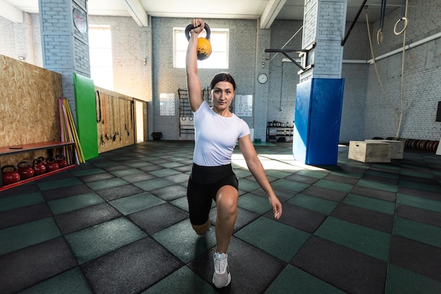 Vrouw die aan gymnastiek op ringen doet in de sportschool