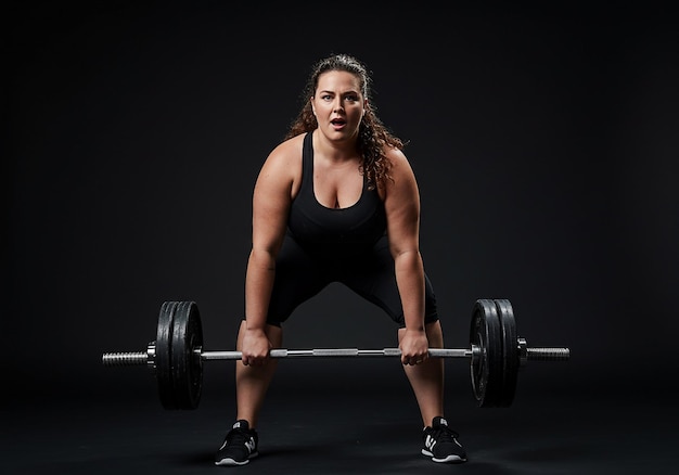 Vrouw die een deadlift met een halter uitvoert in een sportschool