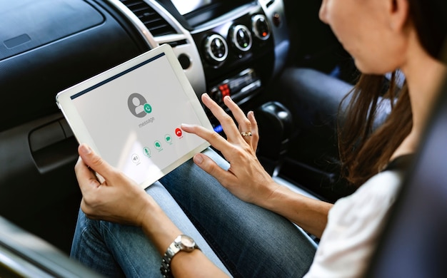 Vrouw die een digitale tablet in de auto gebruikt